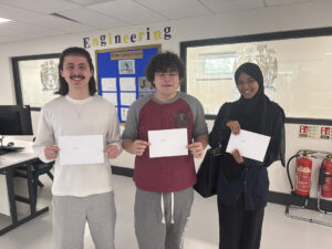 Three students holding a certificate